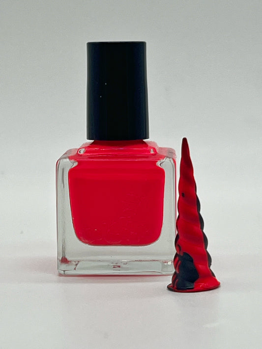 neon pink nail polish in a square bottle with black lid next to a small black unicorn horn that has been dripped with the paint