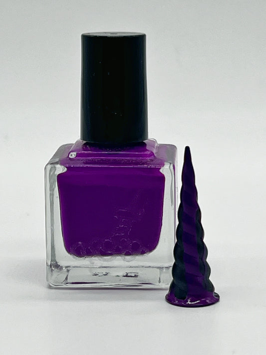 Purple nail polish in a cube glass bottle with black lid and a small black unicorn horn with the color dripping from the tip down
