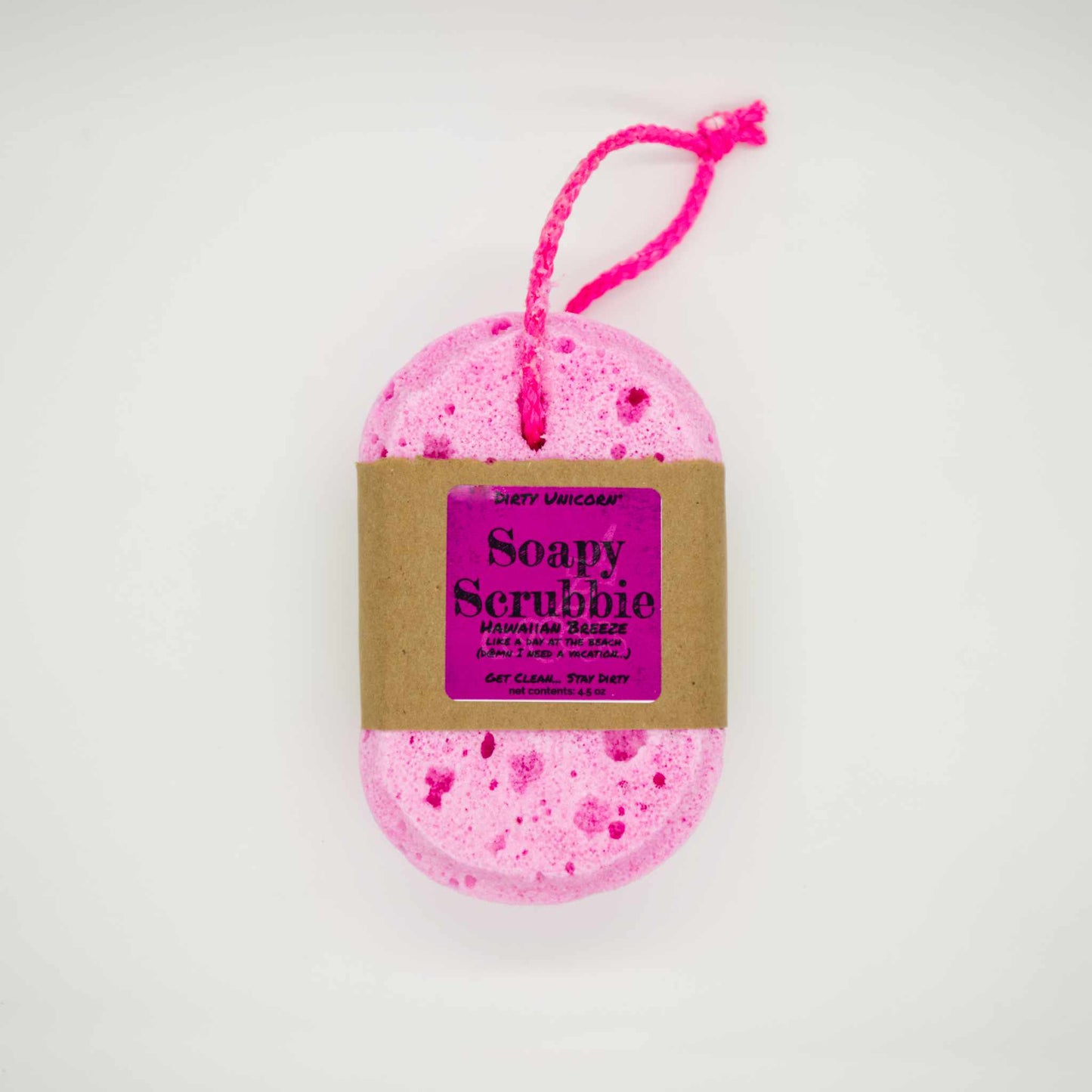 bright pink bath sponge with pink rope for hanging on blank white background. Sponge is wrapped in brown Kraft paper belly band with a pink label barring product title