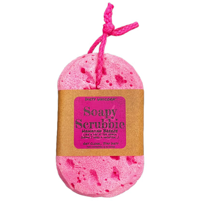 Bright pink bath sponge with pink hanging rope on a white background, wrapped in a brown kraft paper belly band with a pink label bearing the product title.
